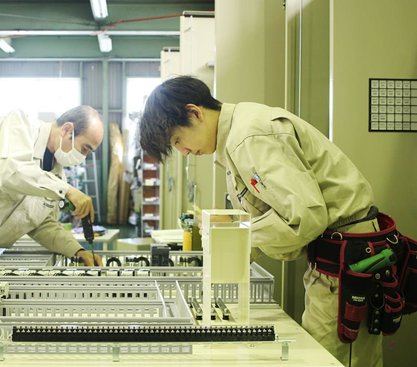 基盤にドリルで穴をあける堀内電機製作所のスタッフ